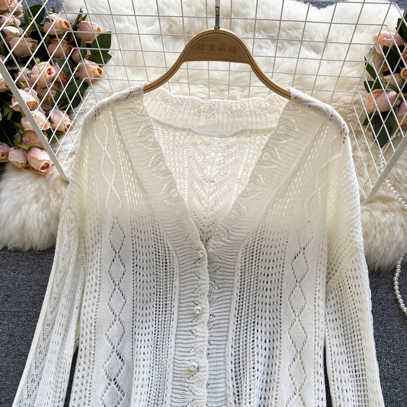 Sanfter Wind trägt einen ausgehöhlten Vintage-Strickjackenmantel mit Hakenblume 1580